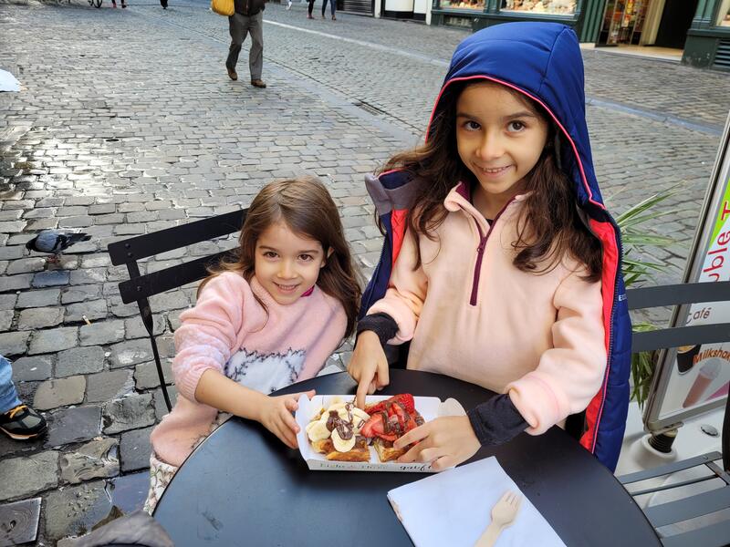Minhas filhas se deliciando com um waffle na Grand Place de Bruxelas