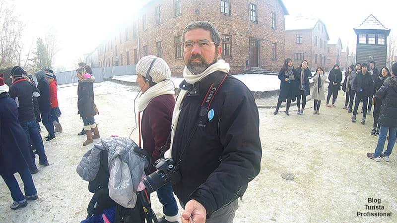 Turista Profissional e grupo de visitantes com guia durante excursão guiada por Auschwitz-Birkenau